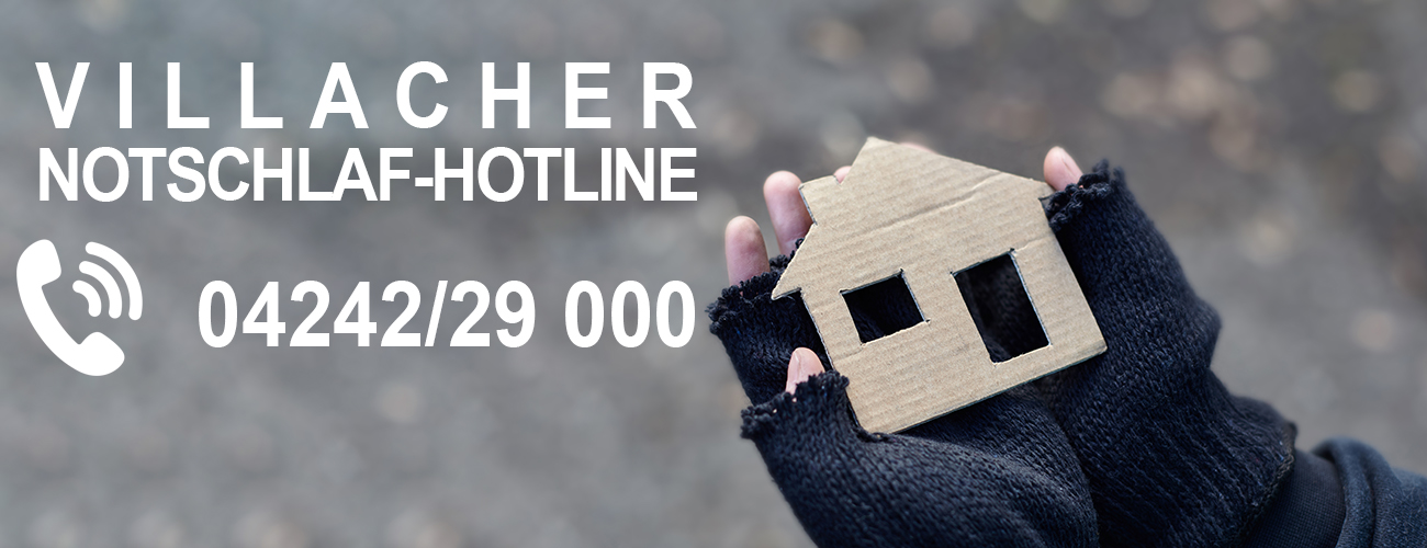 Handschuhe mit Löchern halten ein kleines Haus aus Karton