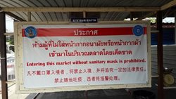 Hinweis zum Tragen eines MNS bei Betreten eines Marktes in Jomtien, Thailand.