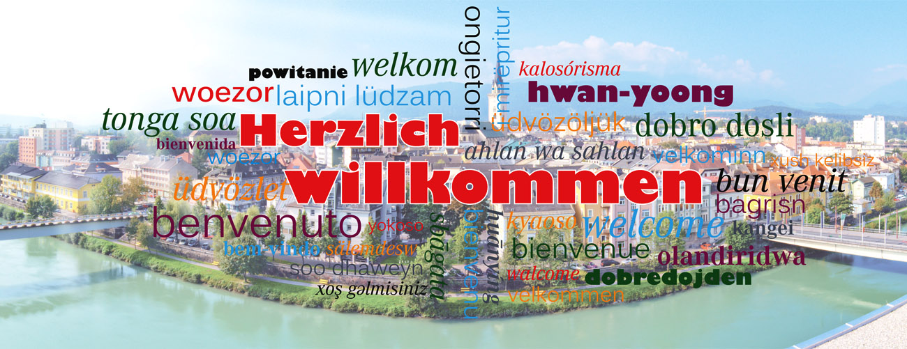 Stadtansicht auf Villach mit Herzlich Willkommen Slogans in mehreren Sprachen